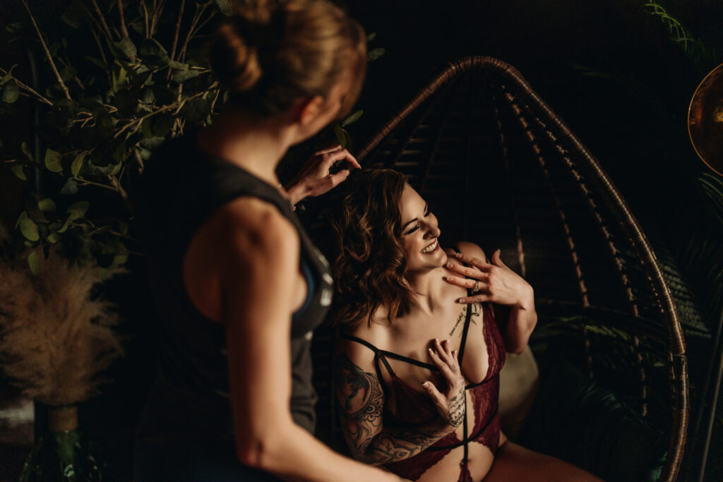 Ashley laughing mid-pose while Rachel fluffs and fixes her hair