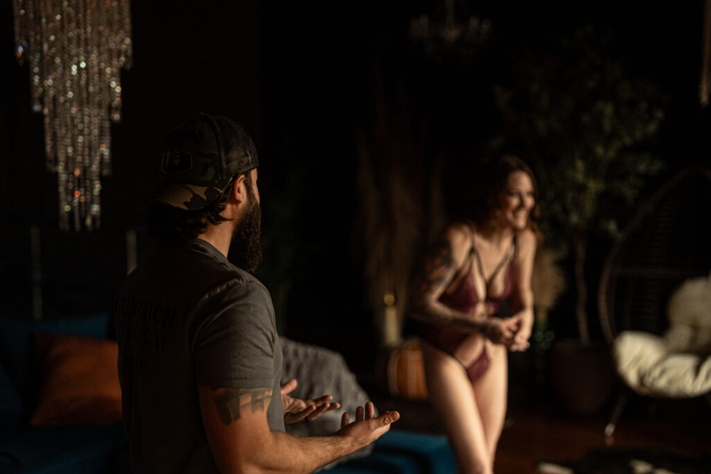 Justin in the foreground explaining something while Ashley is in the background laughing